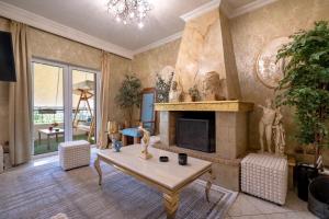 een woonkamer met open haard en een tafel bij Olympus Grand Retreat with Jacuzzi in Athene