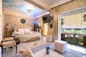 een slaapkamer met een bed en een woonkamer bij Olympus Grand Retreat with Jacuzzi in Athene