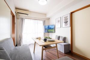 un soggiorno con un tavolo e un divano di Centrally Located in Matsumoto, 1 Free Parking, 2 BR APT a Matsumoto