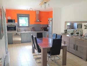 una cucina con un tavolo di legno e sedie nere di La Maison de Rolie a Plévin Altre 8 foto