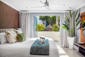 a bedroom with a bed with slippers on it at Rancho Relaxo by Host Agents in Bloubergstrand +54 photos