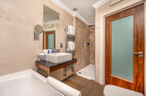 a bathroom with a white tub and a sink at Rocpool Reserve Hotel in Inverness