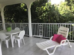 a white porch with a table and chairs at Villa du coeur in Deshaies