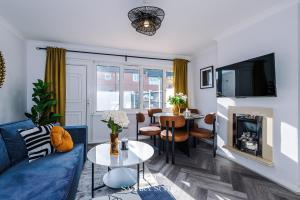 a living room with a blue couch and a tv at Stylish 3BED - Liverpool Centre - Parking - Sleep 5 in Liverpool