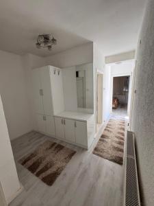 an empty living room with white cabinets and a rug at Apartment City Strumica in Strumica