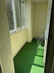 an empty room with a green floor and a window at Apartment City Strumica in Strumica