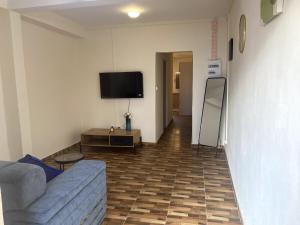 a living room with a couch and a flat screen tv at Charmant T2 a Mtsapere Mamoudzou in Mamoudzou