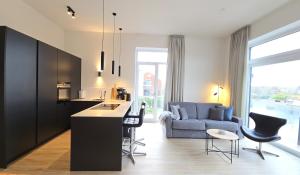 a kitchen and living room with a blue couch at Ferienwohnung "Strandgut" in 1 Reihe an der Ostseeküste in Kalifornien