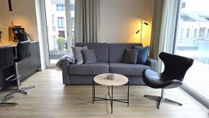 a living room with a couch and a table and chairs at Ferienwohnung "Strandgut" in 1 Reihe an der Ostseeküste in Kalifornien