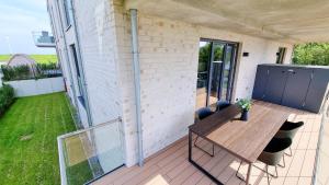 eine Terrasse mit einem Holztisch auf dem Balkon in der Unterkunft Ferienwohnung "Seeräuber" in Schönberg-Kalifornien in Kalifornien