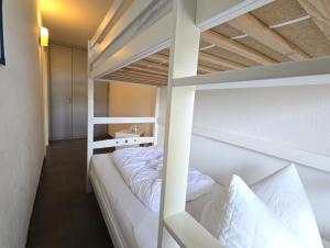 ブラズィリアンにあるFerienwohnung "Deichwind" in Holm an der Ostseeのベッドルーム1室(二段ベッド2組、白い枕付)