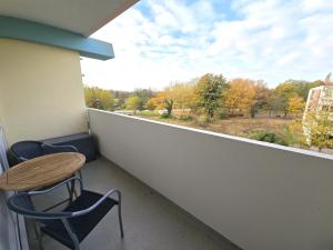 ブラズィリアンにあるFerienwohnung "Deichwind" in Holm an der Ostseeのバルコニー(テーブル、椅子付)、窓が備わります。