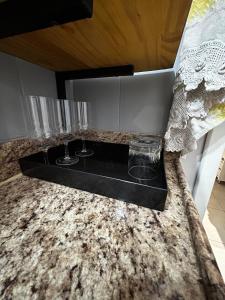 two glasses on a black tray on a counter at Loft com área de trabalho isolado - Centro do Rio de Janeiro in Rio de Janeiro
