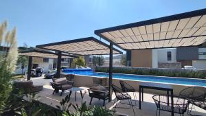 a patio with chairs and tables and a swimming pool at Perfect for Vacationing in San Vicente Ferrer