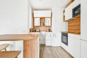 a kitchen with white cabinets and a wooden counter top at Gaspar- Passages- Comfort & proximity to Paris in Boulogne-Billancourt +4 photos
