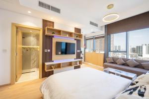 a bedroom with a bed and a couch at Luxury Studio JVC Open View in Dubai