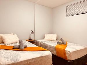 a bedroom with two beds with stuffed animals on them at Hora Quente in Windhoek