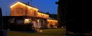 a house with lights on the side of it at night at B & B Arzilla in Rosciano