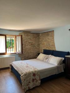 a bed in a bedroom with a brick wall at B & B Arzilla in Rosciano