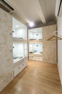 a room with white bunk beds and wooden floors at Modular Dreams in Madrid