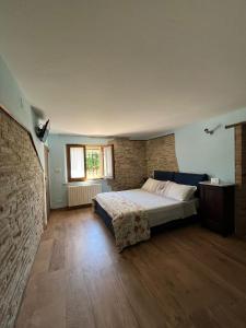 a bedroom with a bed and a brick wall at B & B Arzilla in Rosciano