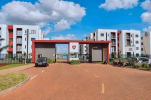 a car parked in a parking lot in front of a building at Tatu City Two Bedroom Apartment in Tatu City