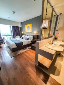 a bedroom with a bed and a sink and a mirror at Novotel Hotel Residence Manila at Acqua in Manila