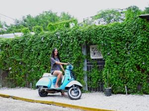 a woman riding a scooter in front of a building at The Backside House - Women Only - in Tamarindo