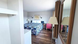 a hotel room with a bed and a desk at Motel et Chalets l'Acadien sur mer in Petit Rocher