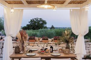 a table set up for a dinner party under a pavilion at Trulli Arborea in Alberobello