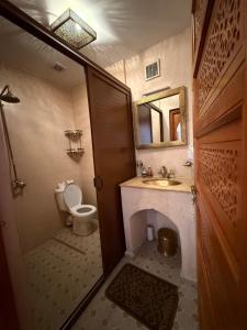 une salle de bain avec toilettes, lavabo et miroir dans l'établissement Riad Jenan Adam, à Marrakech 172 autres photos