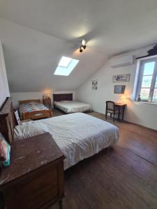 ein Schlafzimmer mit zwei Betten, einem Tisch und einem Fenster in der Unterkunft L'écrin du Temps in Brocas