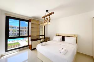 a bedroom with two beds and a large window at G-Cribs El Gouna - Apartments with Pool Access in El Gouna