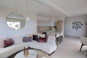 salon z białą kanapą i kuchnią w obiekcie MonteCarloSeaView & Jacuzzi & Parking #29 w mieście Saint-Roman