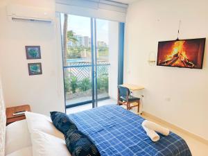 a bedroom with a bed with a tv on the wall at Habitación Suite Cerca al Mar - Santa Marta in Santa Marta