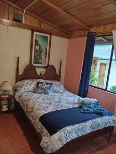 a bedroom with a bed in a room with a window at Larita's MINDO Hospedaje y casita de Campo Los Guayabales in Mindo