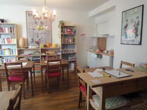 a dining room with tables and chairs and a kitchen at 3 Camere in Basel