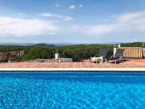 a swimming pool with two chairs and a view at 2 bedroom apartment in Begur center. Sea views, terrace and pool (Ref:H09) in Begur