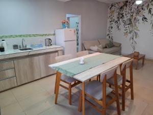 eine Küche und ein Wohnzimmer mit Tisch und Stühlen in der Unterkunft Complejo Los Azahares in Presidencia Roque Sáenz Peña