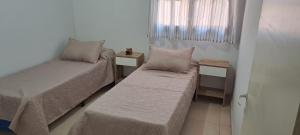 ein kleines Schlafzimmer mit zwei Betten und einem Fenster in der Unterkunft Complejo Los Azahares in Presidencia Roque Sáenz Peña