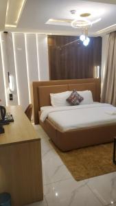 a bedroom with a bed and a desk in it at Del hotel and suites in Mama