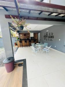 a patio with a table and chairs and a piano at Casa de praia SANTINHO in Búzios