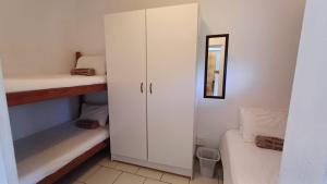 a small room with a white cabinet and a bed at Toti Cabanas in Amanzimtoti