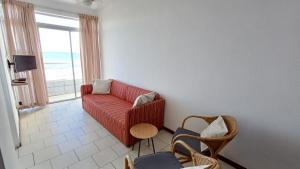 a living room with a red couch and a window at Toti Cabanas in Amanzimtoti