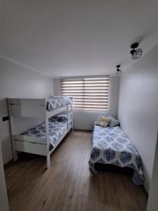 a bedroom with two bunk beds and a window at Departamento nuevo Pucón in Pucón