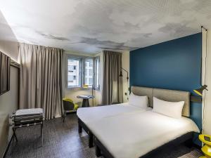 a hotel room with a bed and a blue wall at Hotel ibis Lisboa Saldanha in Lisbon +130 photos