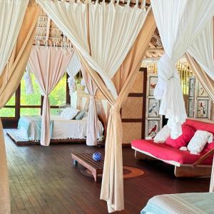 a bedroom with two beds and drapes at Palapa Ganesh in Sayulita