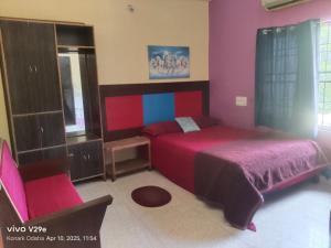 a bedroom with a bed and a chair in it at Hotel Sunshine in Konārka
