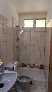 a bathroom with a toilet and a tub and a sink at Appartement confortable à Le Lamentin, 70 m², jardin in Chambort