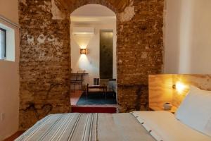 a bedroom with a bed in a room with brick walls at Casa Arrona Oaxaca in Oaxaca City